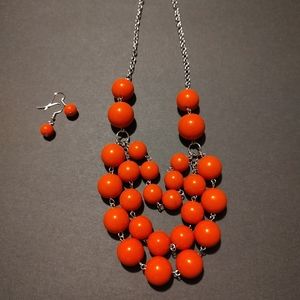 Large orange beaded necklace with matching earrings